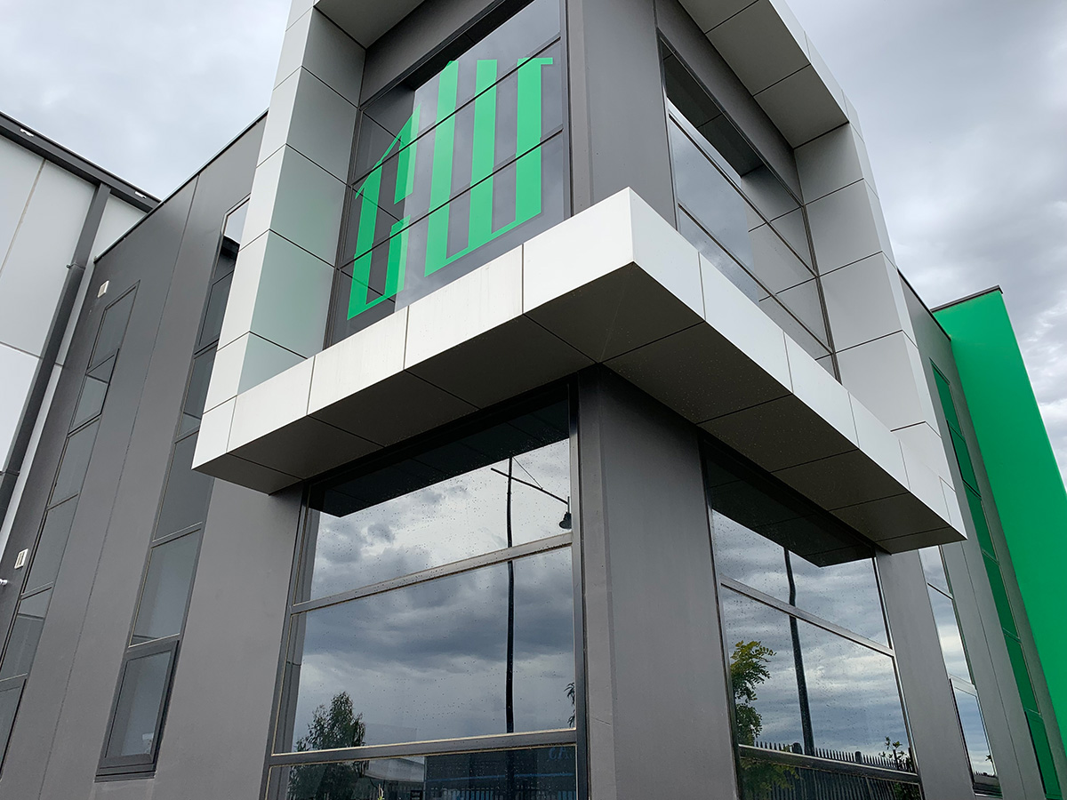 Modern commercial building with large windows and green facade accents