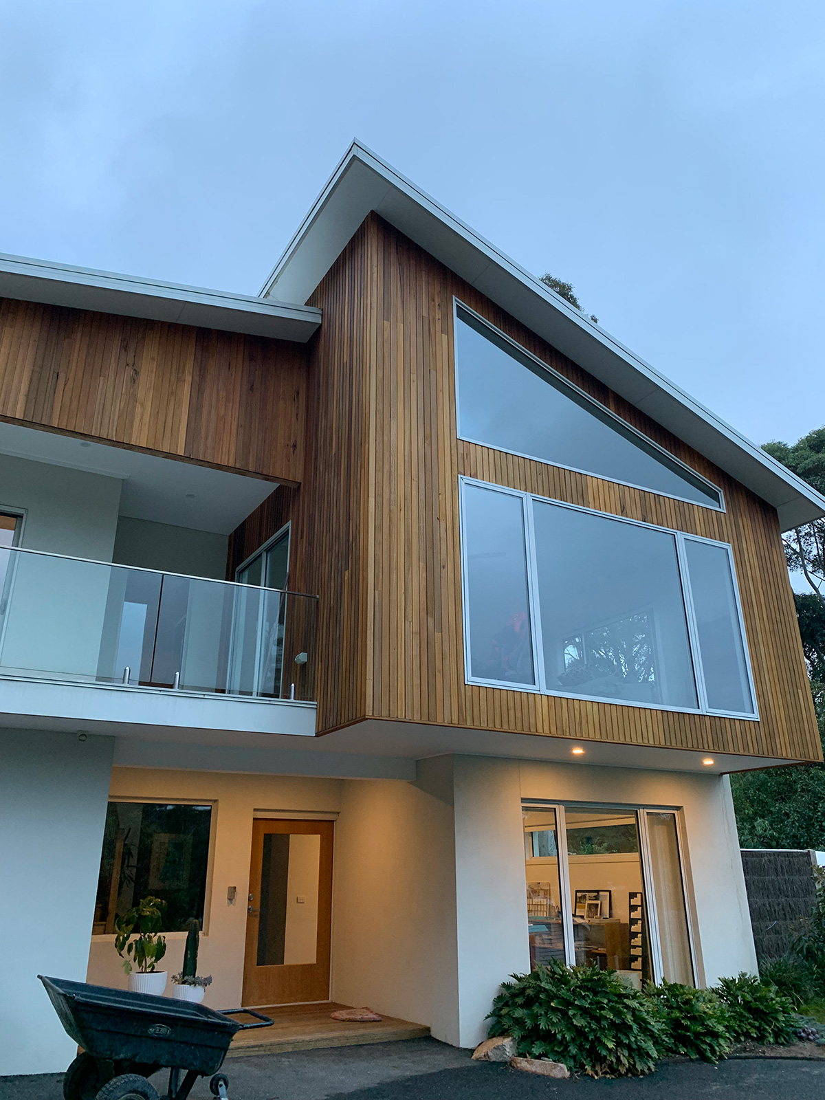 Timber-clad home with a large upper-storey window