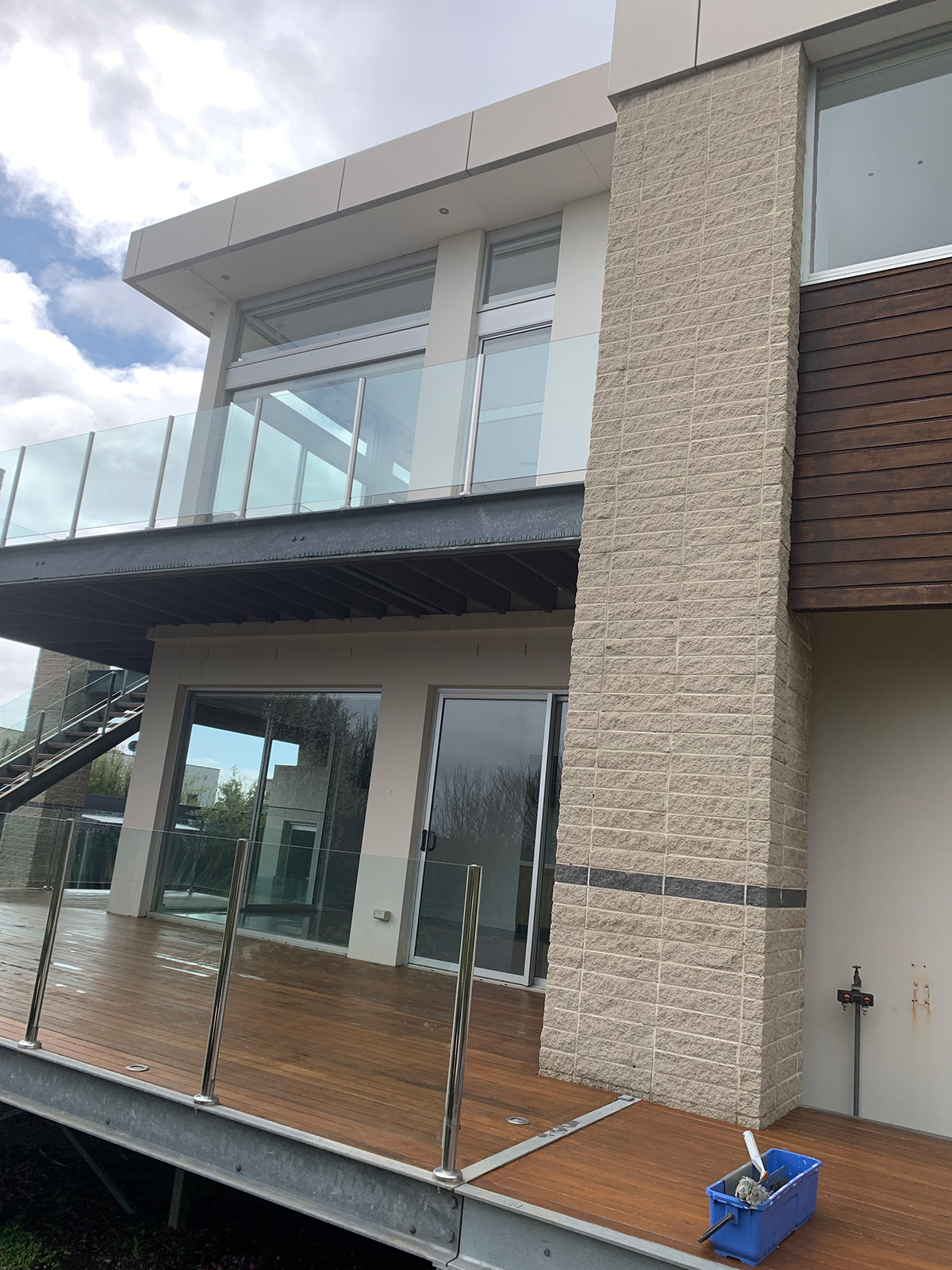 Two-storey home with large windows, a glass balcony and window-cleaning equipment